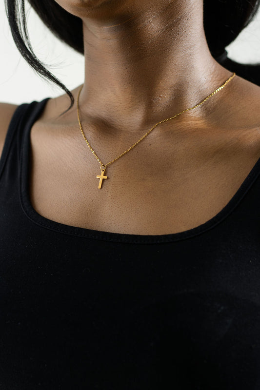 model's neck showing a black tank top with the gold 45cm necklace and a dainty gold cross pendant