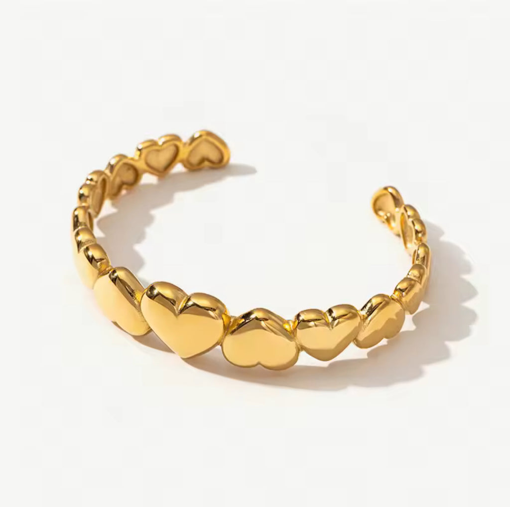 Gold bracelet with heart-shaped links on a white background