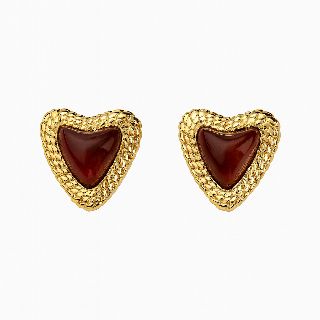 Pair of gold heart-shaped earrings with redish brown stones filled with resin, with gold embellishments  on a white background