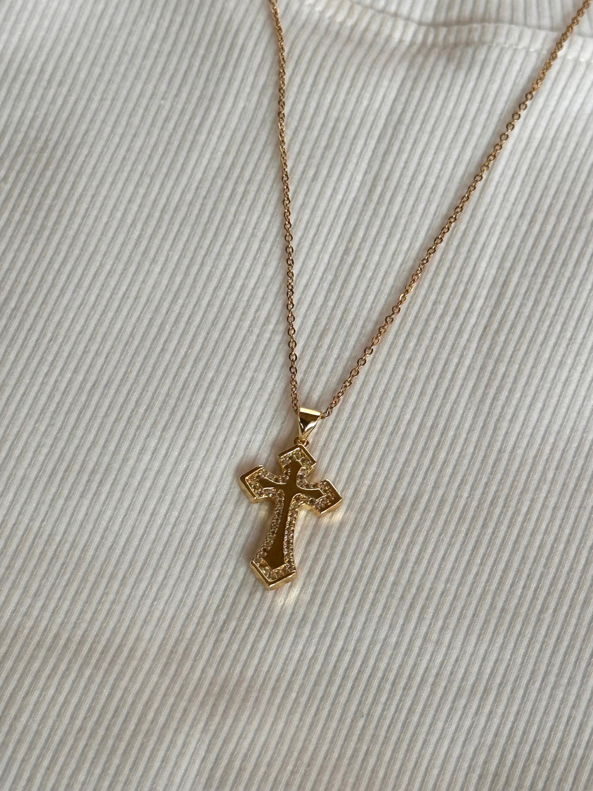 The Truth Cross Necklace styled against a basic white tshirt.