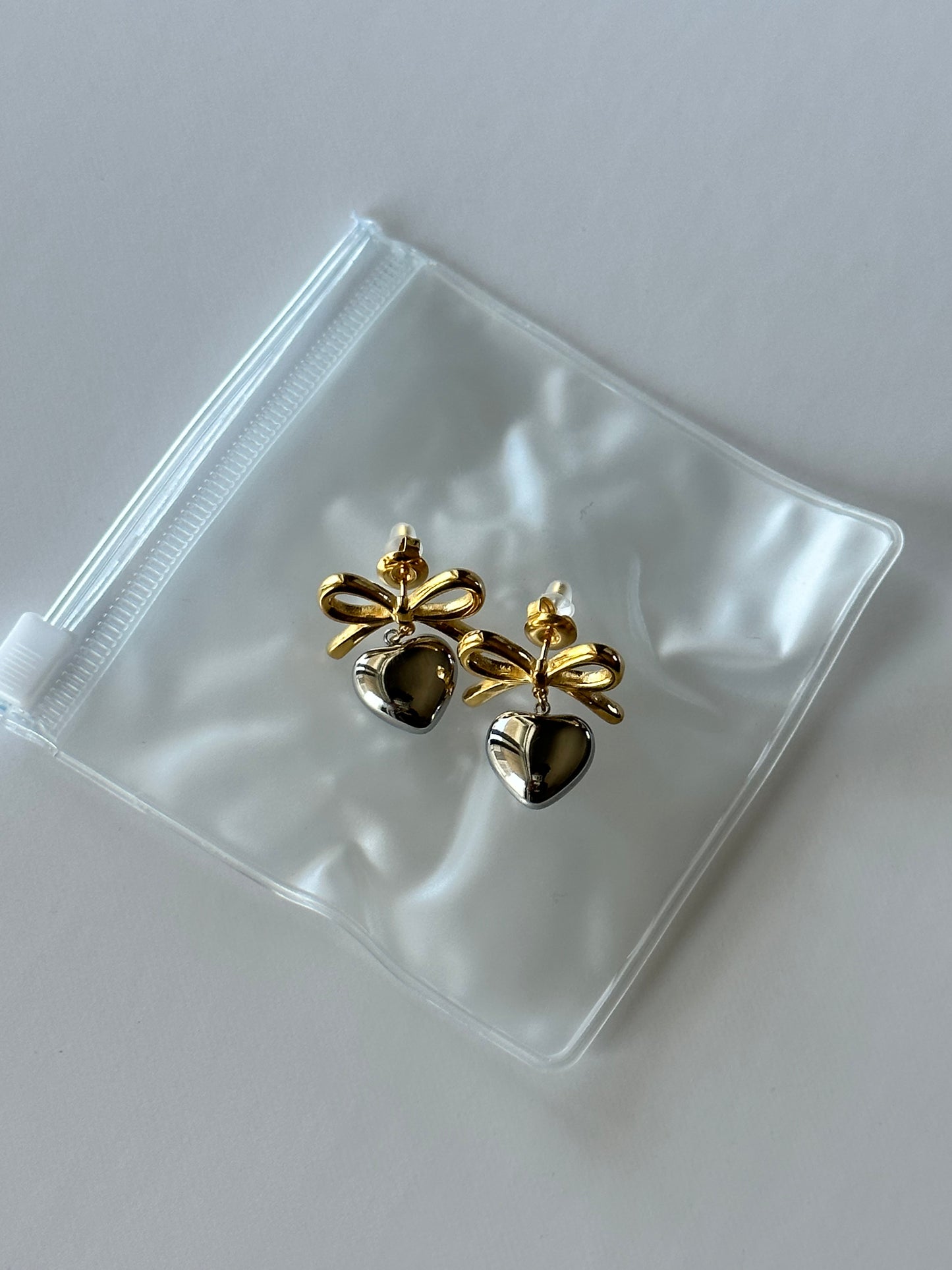 silver and gold earrings for christian girl showing ouch for jewelry.