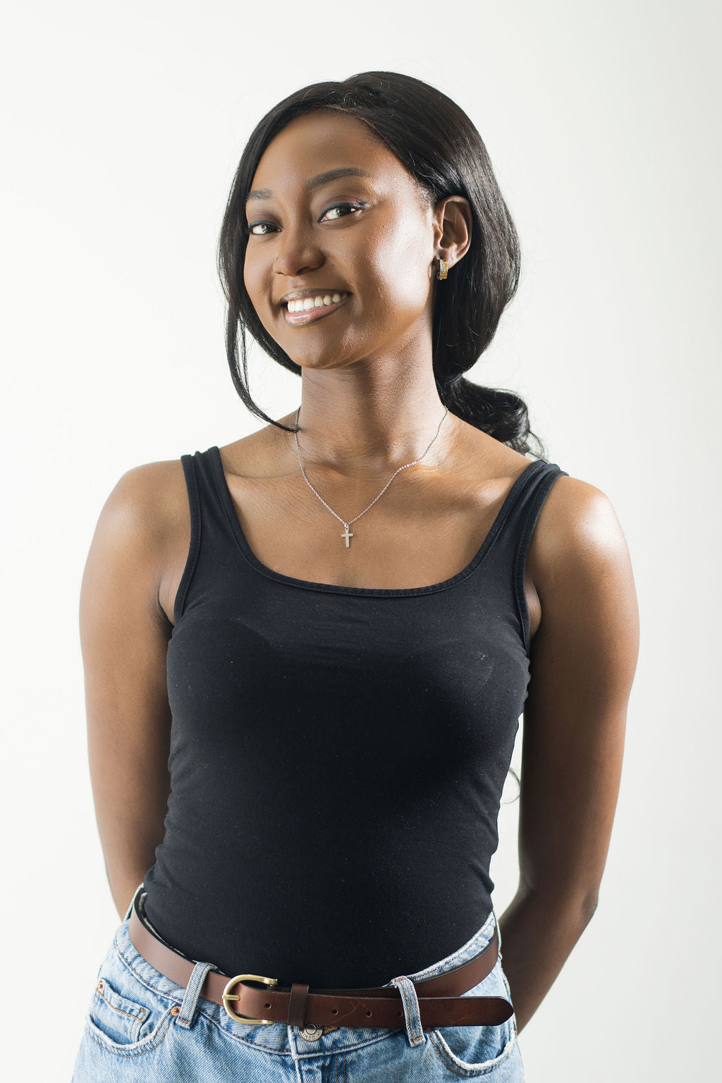 full picture of mode smiling in a black tank top and wearing the mini cross necklace