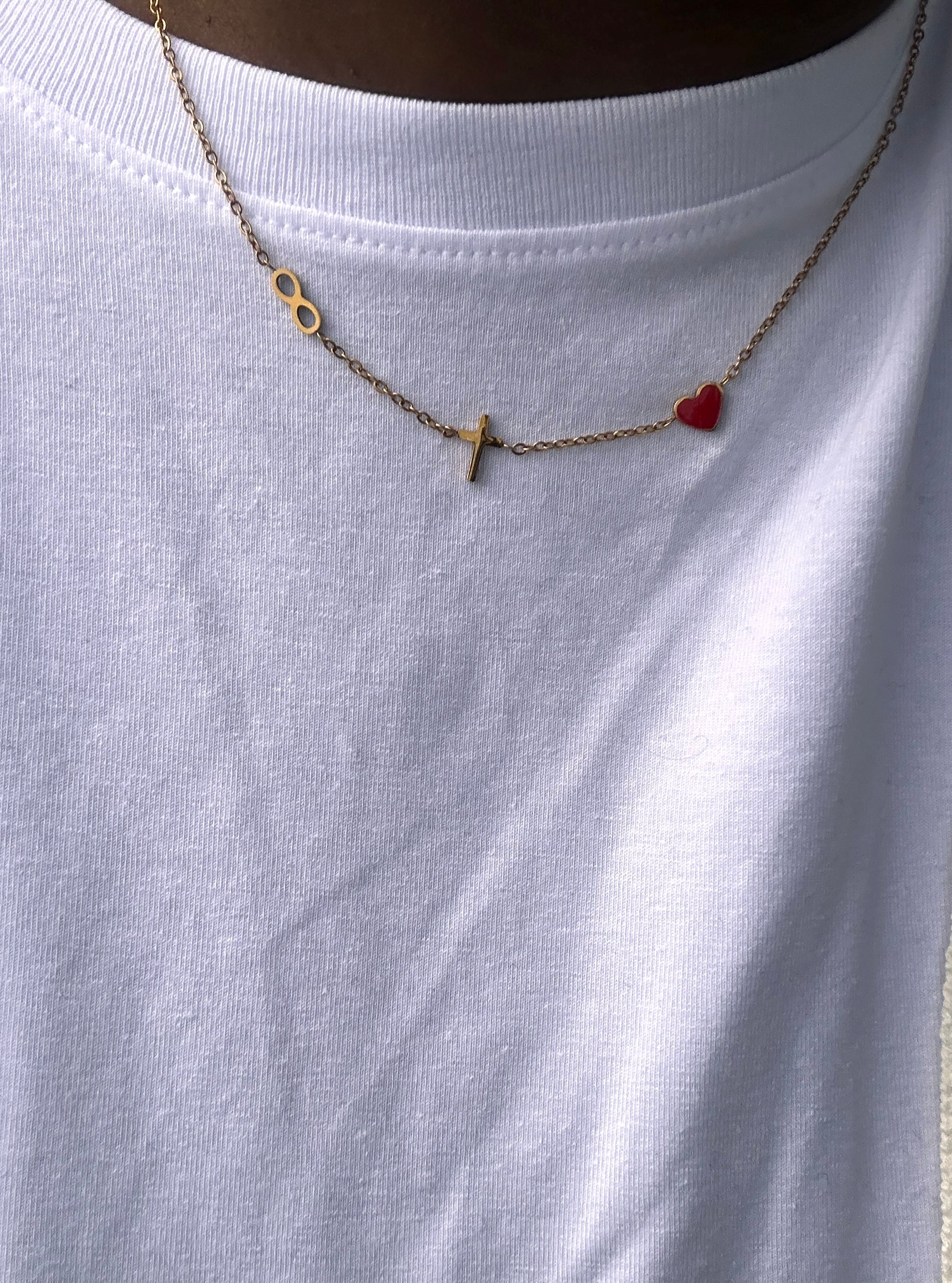 eternity pendant, cross and red heart john 3:16 necklace being worn with a white crew neck shirt